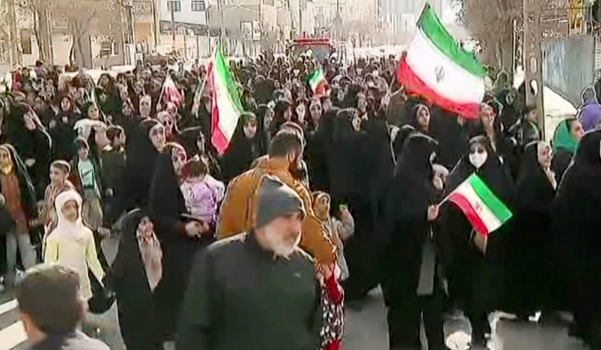 This grab taken from handout video footage released by Iran Press on January 9, 2026, shows pro-government demonstrators holding Iranian flags in Arak, northwestern Iran. (AFP)