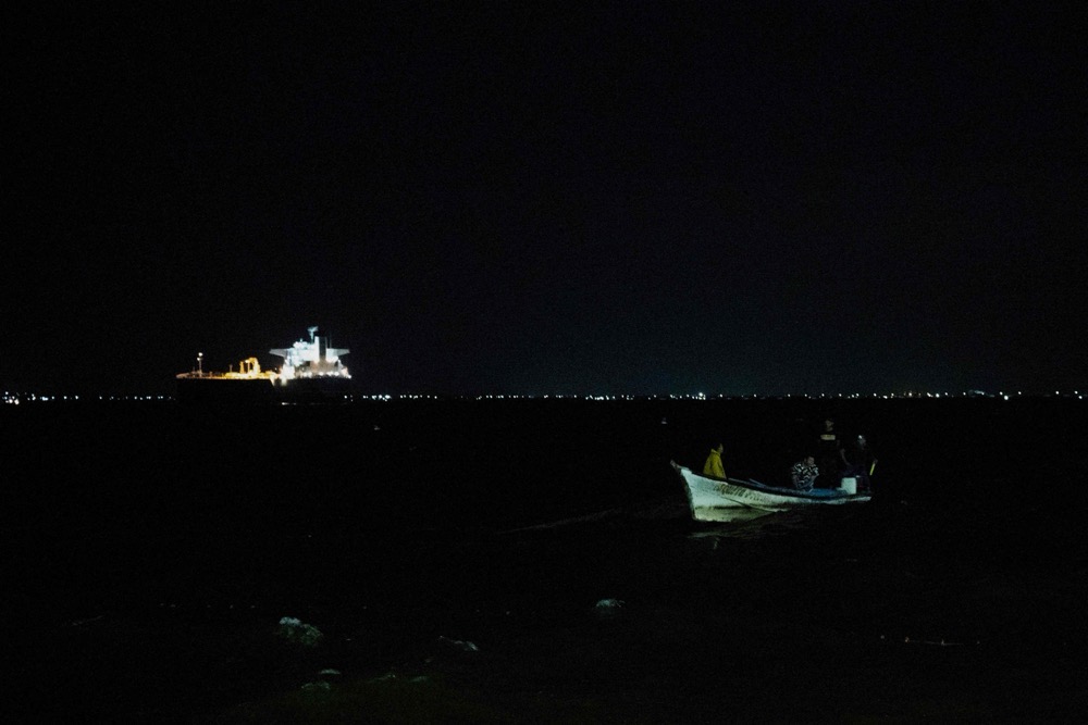A boat sails while in the background is seen a crude oil tanker in the Maracaibo Lake in Maracaibo, Venezuela. (AFP/File)