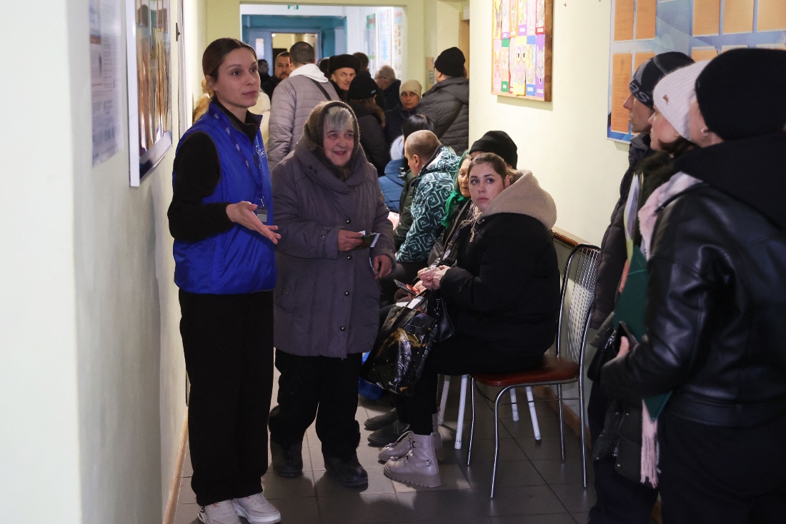 An employee talks to residents who were forcibly evacuated from the villages of Kushuhum and Yuliivka in the Zaporizhzhia region at a transit centre in Zaporizhzhia. (AFP)
