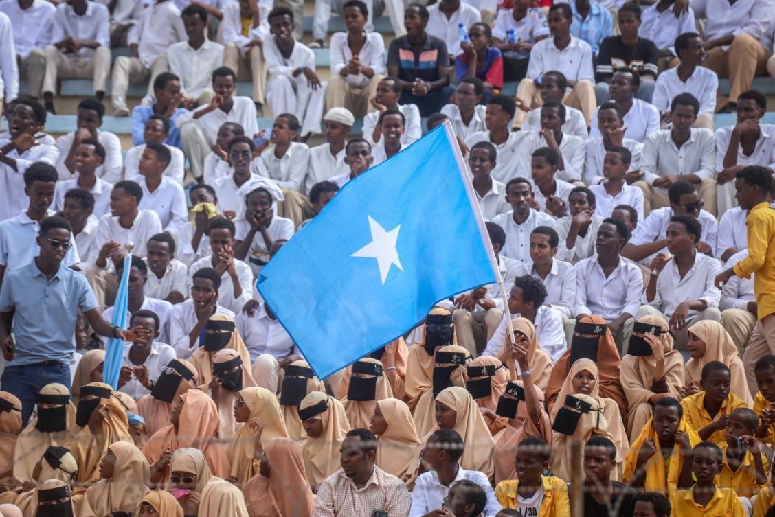 Residents wave Somali flags as they attend a rally denouncing Israel’s recent announcement recognizing the breakaway Somaliland region at Mogadishu Stadium in Mogadishu. (File/AFP)