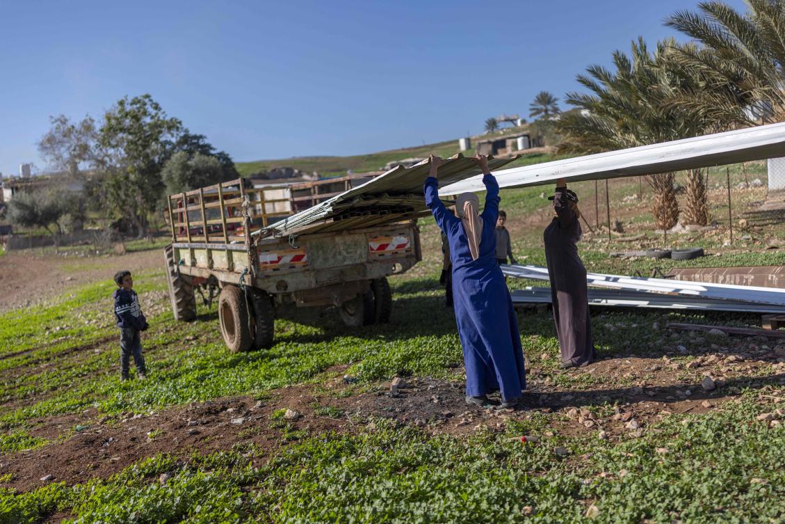 A Bedouin family loads a trailer as they dismantle a structure and gather their belongings to leave their homes after continues harassment from Israeli right-wing settlers in Ras Ein al-Auja, near the city of Jericho in the Israel-occupied Palestinian West Bank on January 11, 2026. (Photo by ILIA YEFIMOVICH / AFP)