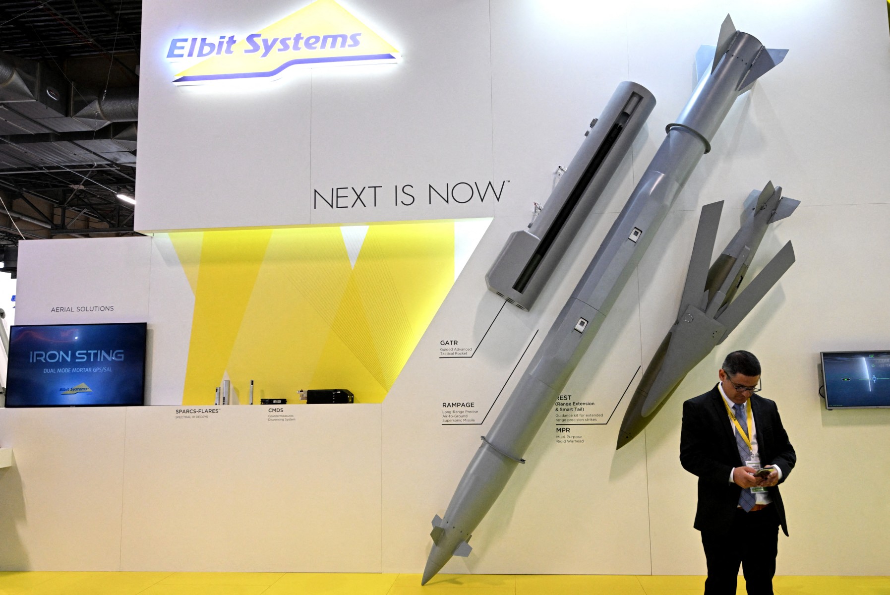 A Israeli defense technology company Elbit Systems' staff member looks at his phone at the Eurosatory international land and airland defence and security trade fair, in Villepinte, a northern suburb of Paris, on June 13, 2022. (File/AFP)