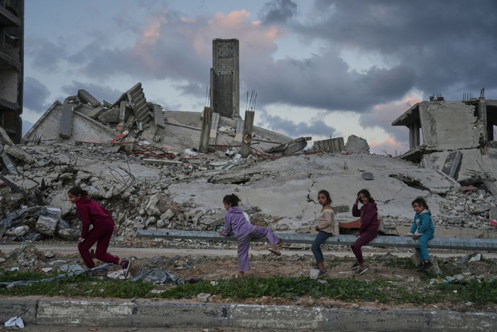 Palestinian girls play amid buildings destroyed by Israeli air and ground operations in the Zeitoun neighborhood of Gaza City, Wednesday, Jan. 14, 2026. (AP Photo)