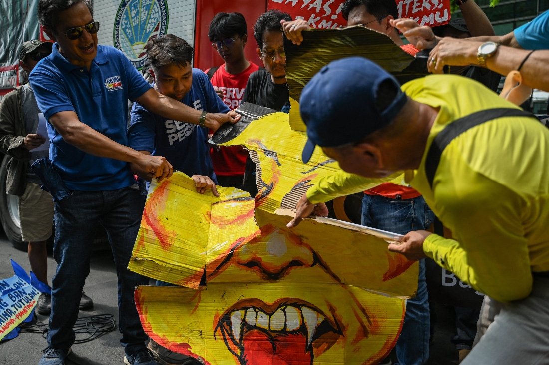 A photo dated 2024 shows protesters rip up a caricature of China’s President Xi Jinping during a rally in front of the Chinese Consulate in Manila, Philippines. (AFP)