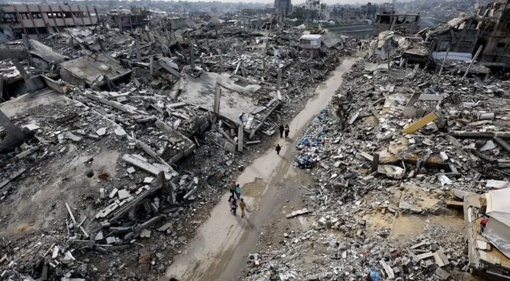 Palestinians walk past the rubble of residential buildings destroyed during the war in the northern Gaza Strip. (Reuters/File Photo)