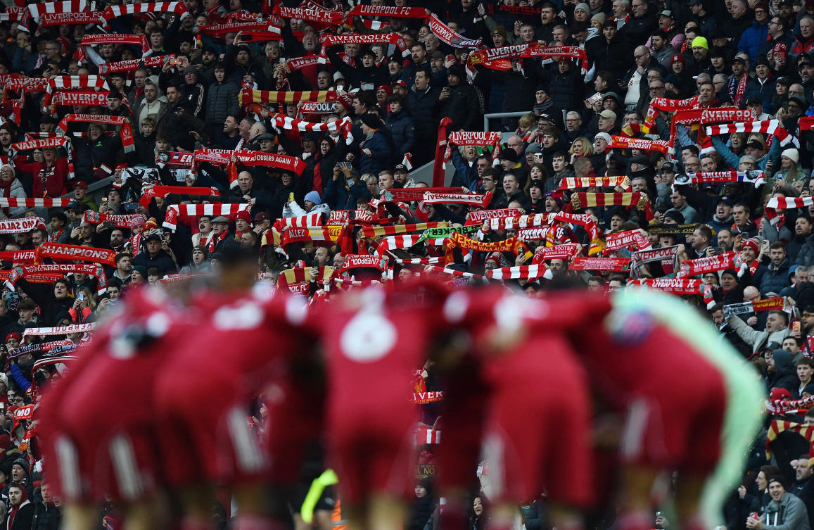 Liverpool fans with scarves in the stands as the players huddle before their Premier League match against Burnley at Anfield, Liverpool, Jan. 17, 2026. (Reuters)