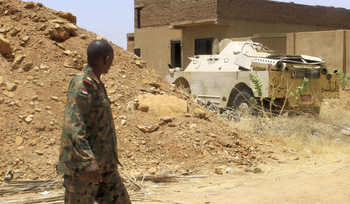 A Sudanese army officer walks near an armoured vehicle seized after their capture of a base used by the rival Rapid Support Forces (RSF) paramilitaries after the latter group evacuated from the Salha area of Omdurman, the twin-city of Sudan's capital, on May 26, 2025. (AFP)