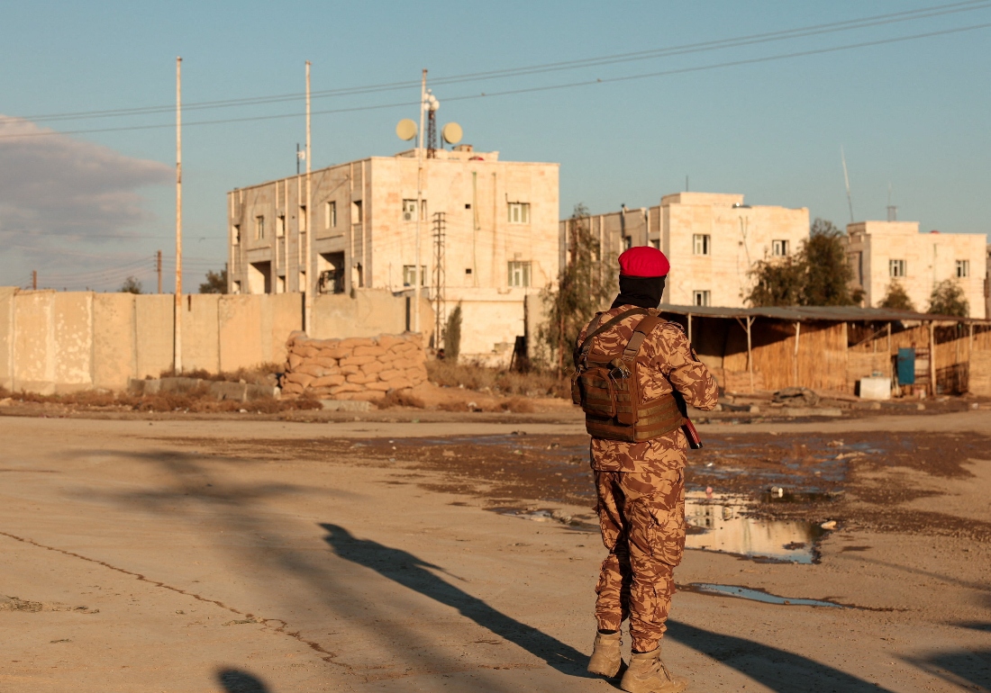 A member of Syrian military police stands guard near Raqqa prison, where the Syrian army is besieging SDF members after the army took control of the city of Raqqa, Syria. (Reuters)
