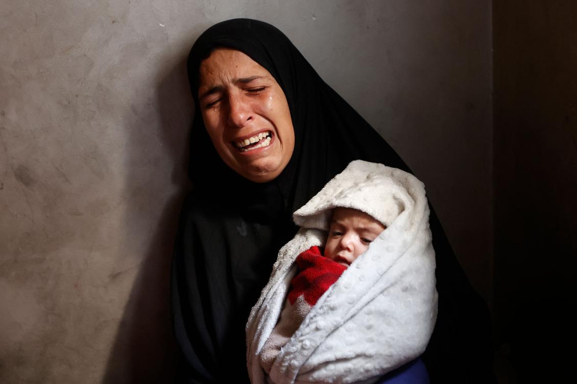 Hiba Abu Jarad, 30, mother of three-month-old Palestinian baby Shatha Abu Jarad, who died from cold, cries while holding Nada, Shatha's twin sister, in Gaza on Tuesday. (AFP)