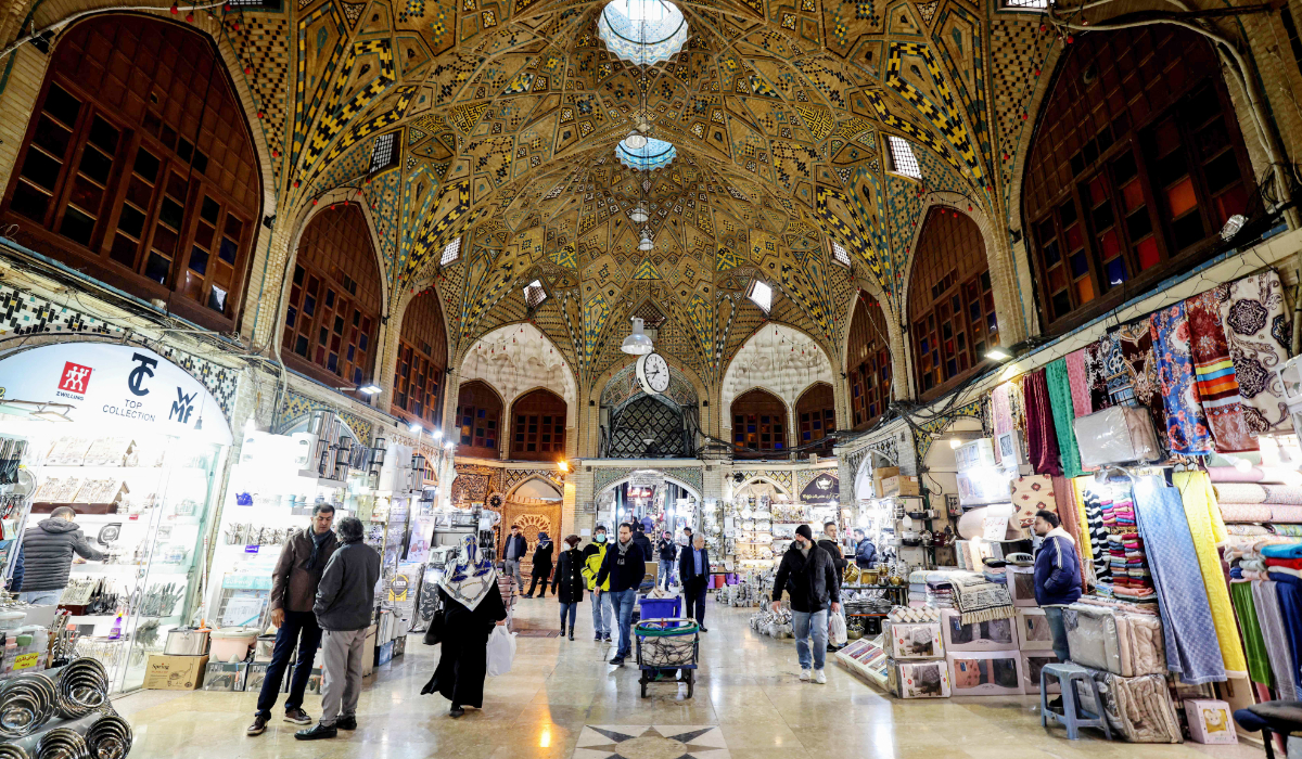 Iranians walk past shops at the Grand Bazaar in the capital Tehran on January 20, 2026. (AFP)