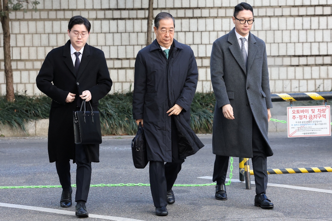 Former South Korean Prime Minister Han Duck-soo (C) arrives at the Seoul Central District Court for his first sentencing trial in the insurrection case. (Pool via REUTERS)