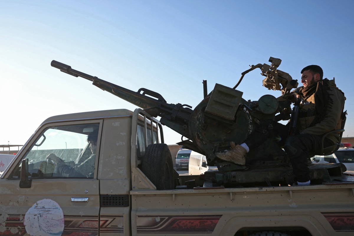 Members of Syrian security forces drive a vehicle mounted with a gun as they enter the Al-Hol camp in the desert region of Hasakeh province, Jan. 21, 2026. (AFP)