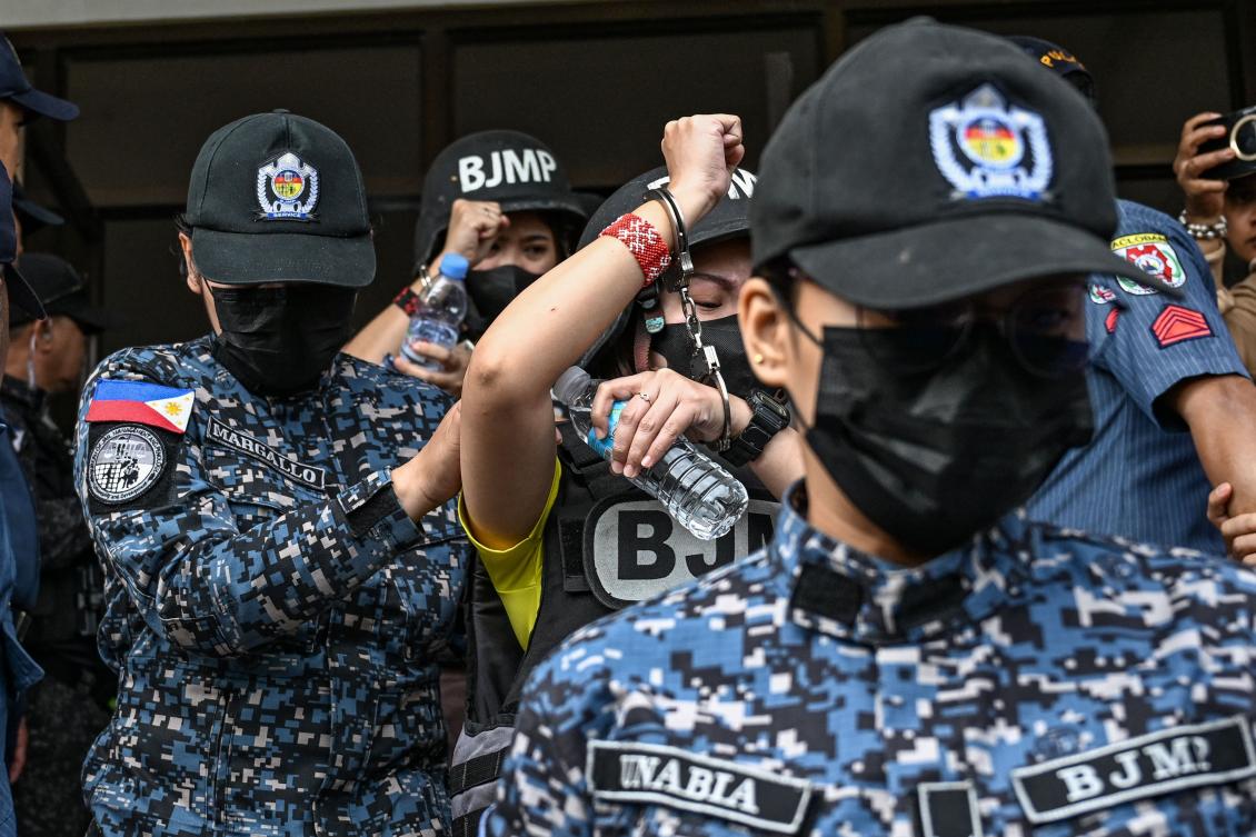 Frenchie Mae Cumpio, back, wearing yellow, and her former roommate Marielle Domequil, front, wearing yellow, leave Tacloban Regional Trial Court in Leyte island on January 22, 2026, after the promulgation of her court case. (AFP)