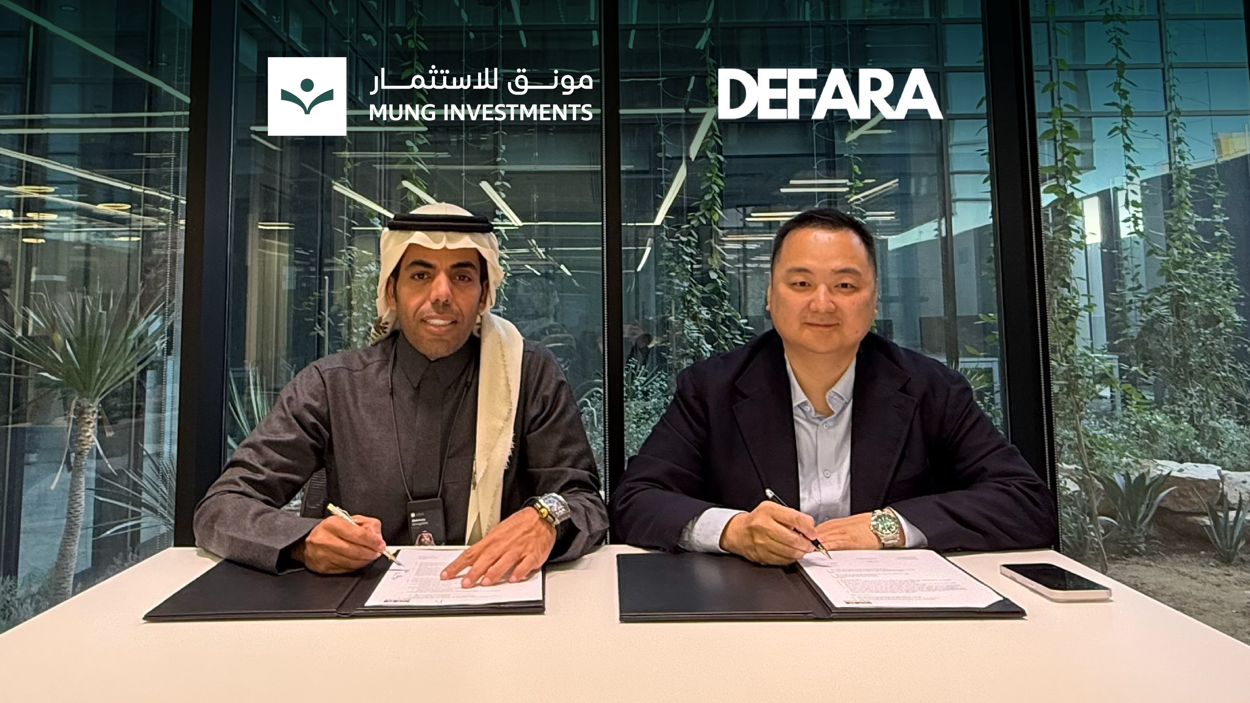 Abdulaziz Al‑Muqayteeb, founder and CEO of Mung Investments, signs an agreement with Shi Song, co‑founder of DEFARA, during the ceremony