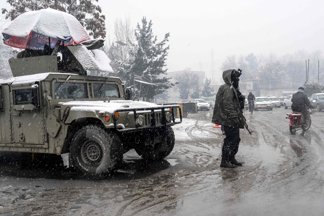 A Taliban security personnel stands guard at a checkpoint during snowfall in Kabul, Afghanistan. (AFP)