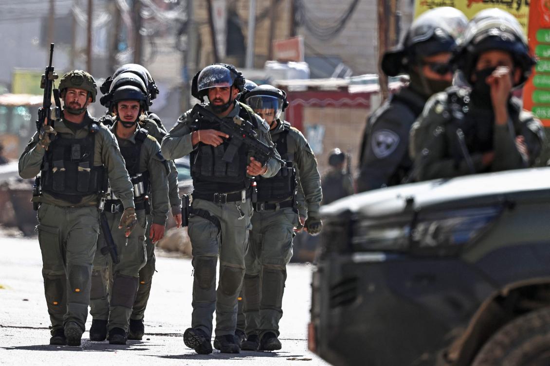 Members of Israeli security forces patrol along a street during a military raid in the neighbourhood of Kafr Aqab near Ramallah on Monday. (AFP)