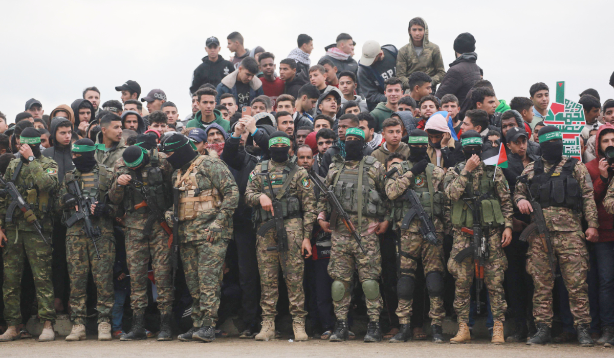 Palestinian Hamas fighters and people gather in Nuseirat in the central Gaza Strip, as preparations take place for the release of three Israeli hostages part of the seventh hostage-prisoner swap on February 22, 2025. (AFP)
