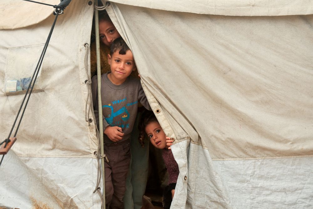 Displaced Palestinian children look out from a shelter on a rainy day in Khan Younis, southern Gaza Strip, Dec. 11, 2025. (Reuters)