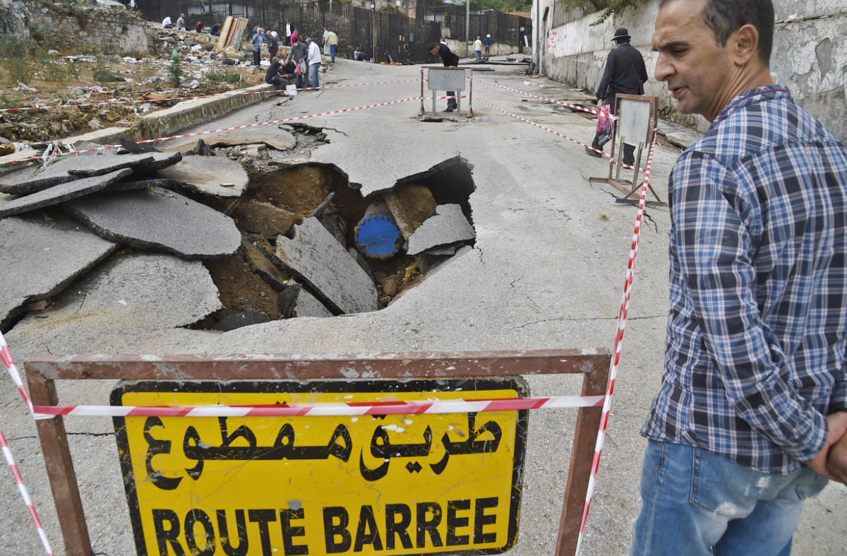 A man stands next to a cordoned off sinkhole caused by heavy rains in the Algerian capital Algiers on September 8, 2020. (AFP file photo)