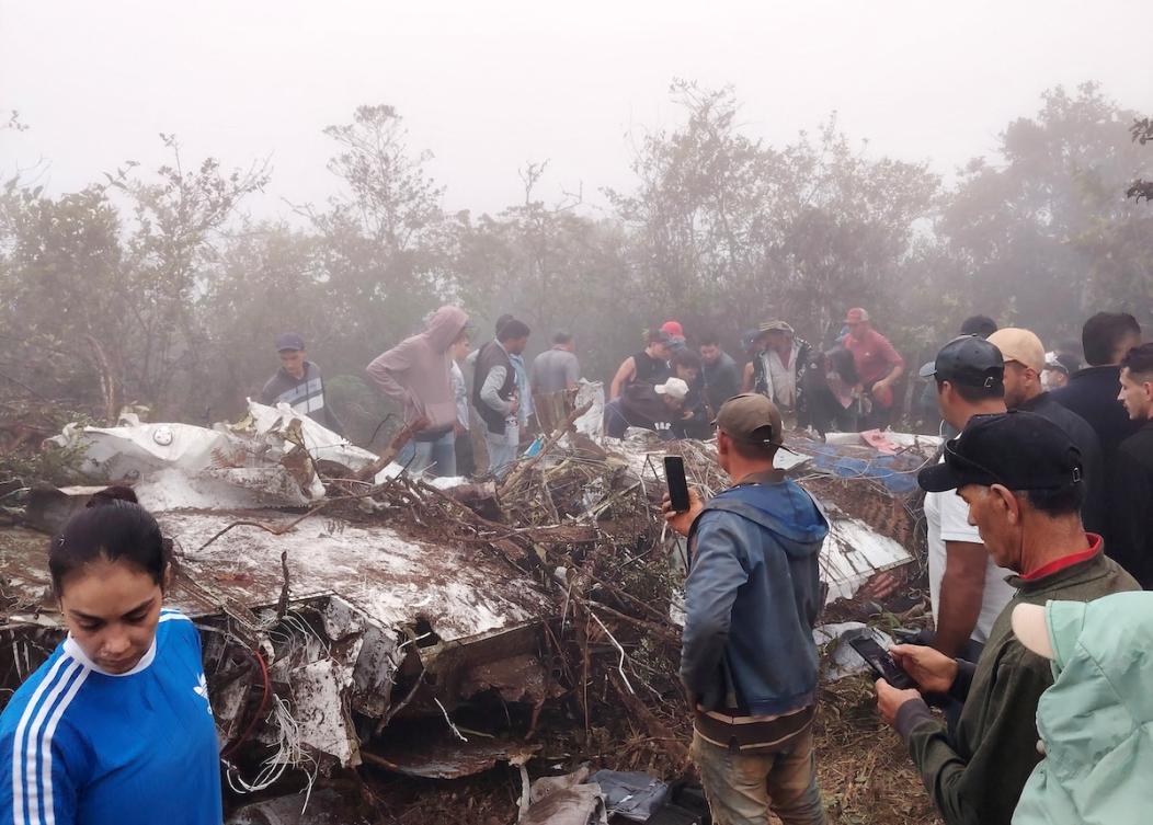 People stand near the wreckage of a plane crash in Colombia, January 28, 2026, in this picture obtained from social media. (Facebook Representative @notiplaya via Reuters)