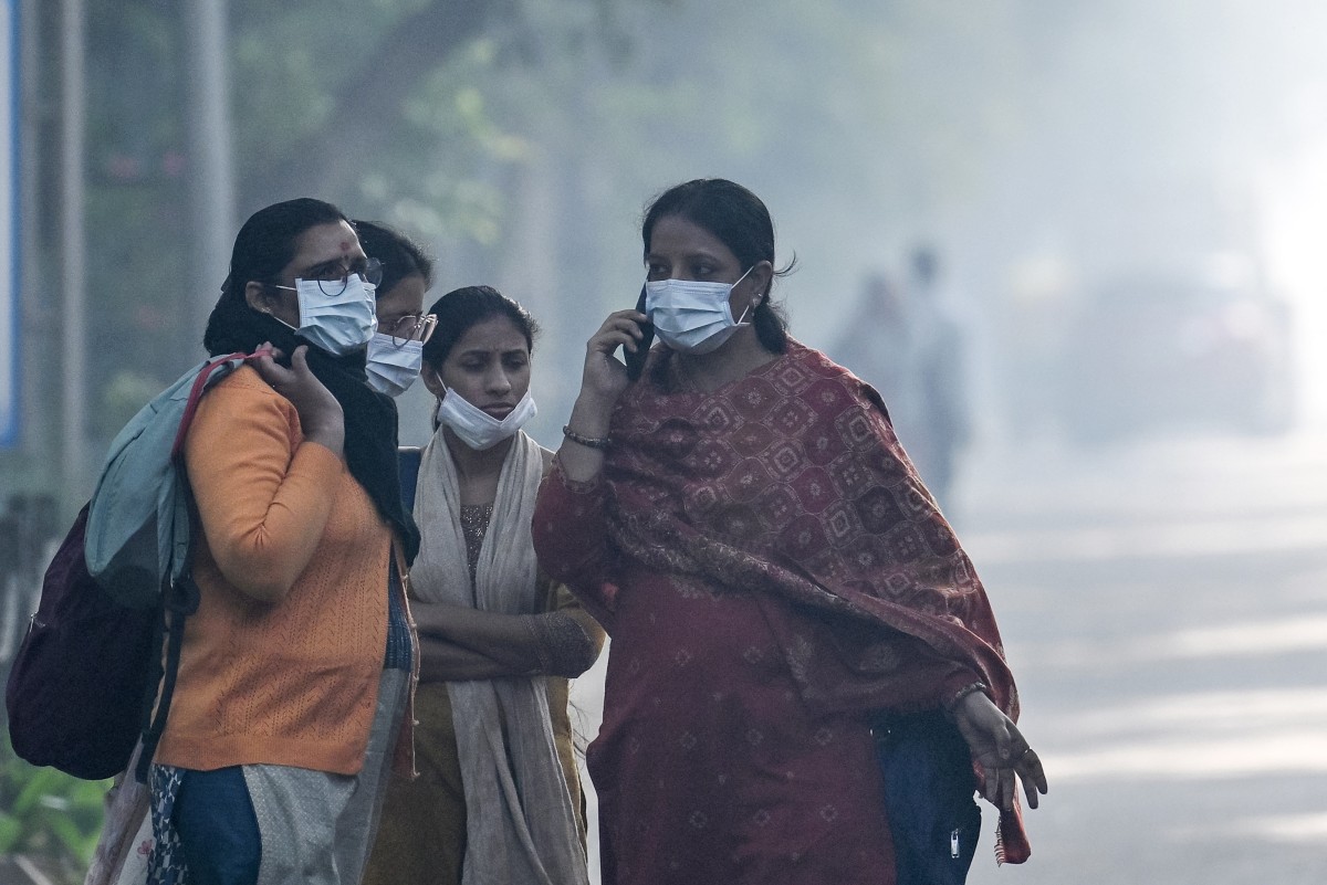 Women wearing face masks wait to board a bus in New Delhi, India, on Nov. 8, 2025. (AFP)