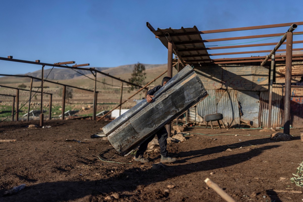 A Bedouin family dismantles a structure as they gather their belongings to leave their home after continues harassment from Israeli right-wing settlers in Ras Ein al-Auja, near the city of Jericho in the Israel-occupied Palestinian West Bank, Jan. 11, 2026. (AFP)