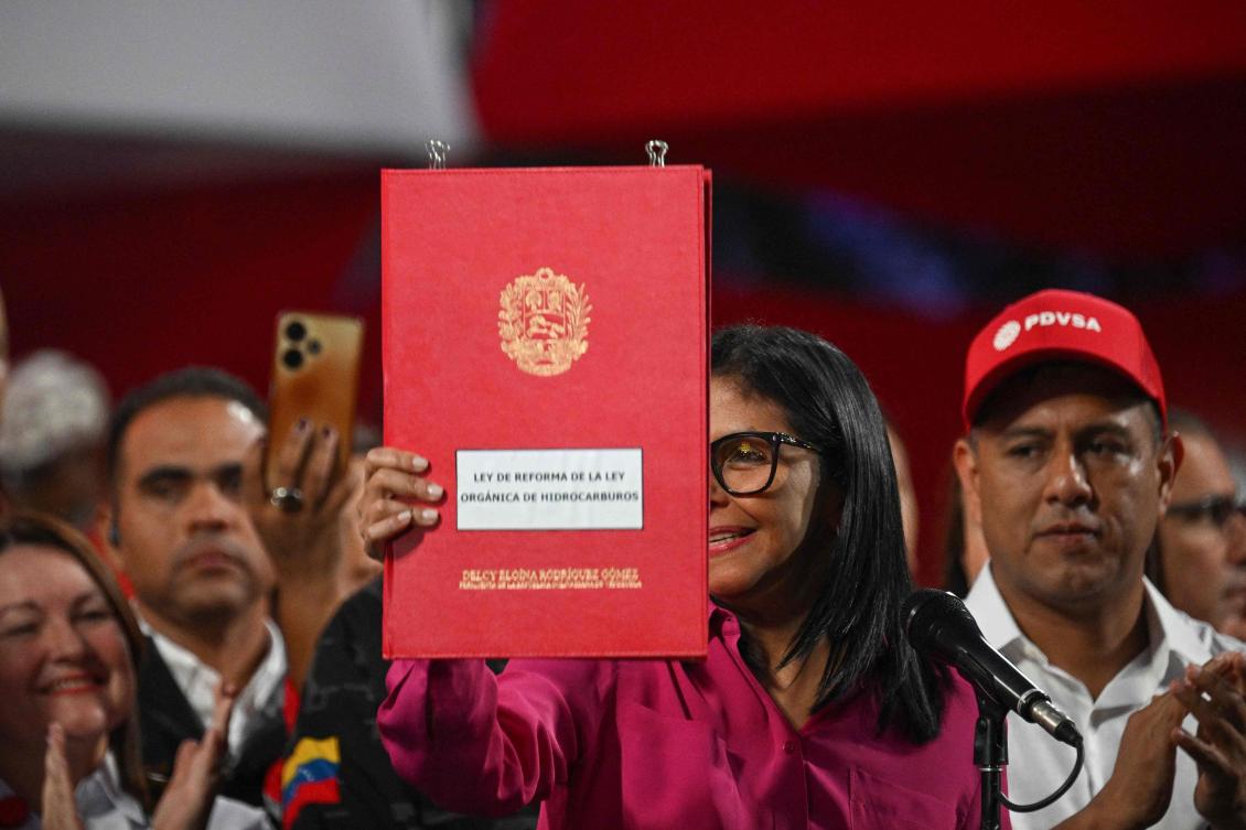 Above, Venezuela’s interim President Delcy Rodriguez holds a copy of the Reform of the Organic Law on Hydrocarbons opening the country’s nationalized oil sector to private investment. (AFP)