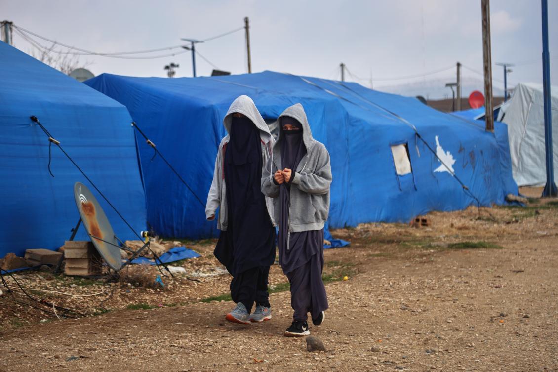 Two women walk among tents at Roj camp, one of the detention facilities holding thousands of Daesh group members and their families, in the Al-Malikiyah area of northeastern Syria, Jan. 29, 2026. (AP)