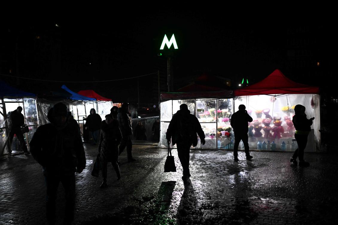 Above, pedestrians walk past kiosks selling flowers and supplied with electricity from power generators during a power outage in Kyiv on Jan. 28, 2026. (AFP)