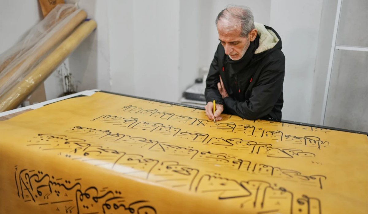 Ali Zaman works in a scroll of a massive handwritten manuscript of the Holy Qur’an in Istanbul. (AP)