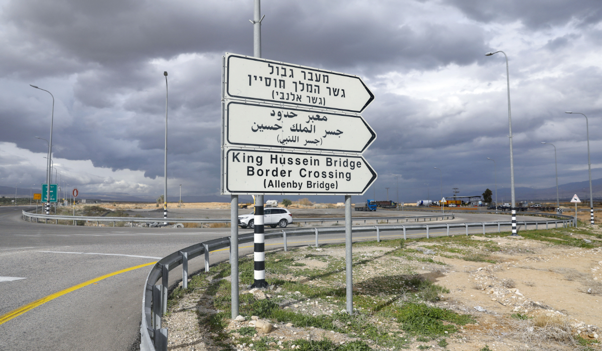 A car drives past a road signal indicating the Allenby (King Hussein) bridge crossing point to Jordan in Jericho. (AFP)