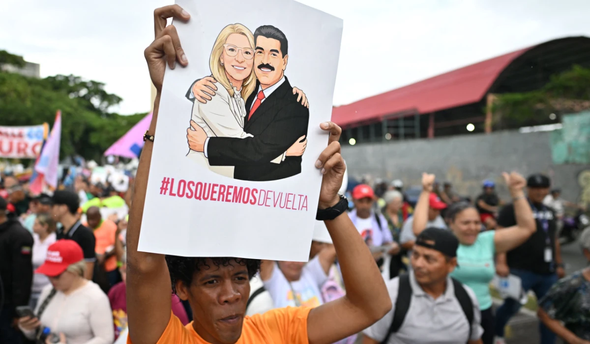 A demonstyrator holds a sign reading "We want them back" with the image of deposed Venezuelan president Nicolas Maduro and his wife Cilia Flores, snatched and taken to New York on January 3 to face trial on drug and weapons charges, during a march in Caracas on January 10, 2026. (AFP)