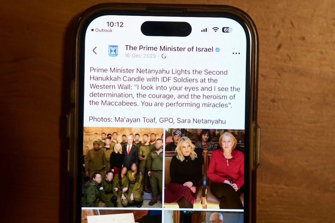 A Facebook post of the Prime Minister of Israel with a retouched photo of the Sara Netanyahu, is displayed on a phone in Ramat Gan, Israel. (AP)