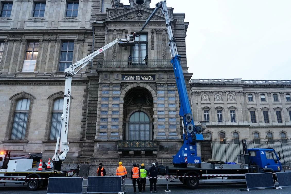 Workers install iron window guards on the window of the Gallerie d’Apollon of the Louvre Museum in Paris on Dec. 23, 2025 a few weeks after thieves used a furniture lift to break into the museum. (AFP)