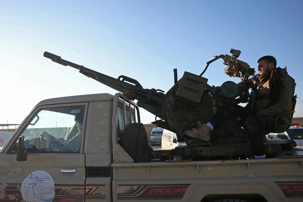 Members of Syrian security forces drive a vehicle mounted with a gun as they enter the Al-Hol camp in the desert region of Hasakeh province, Jan. 21, 2026. (AFP)