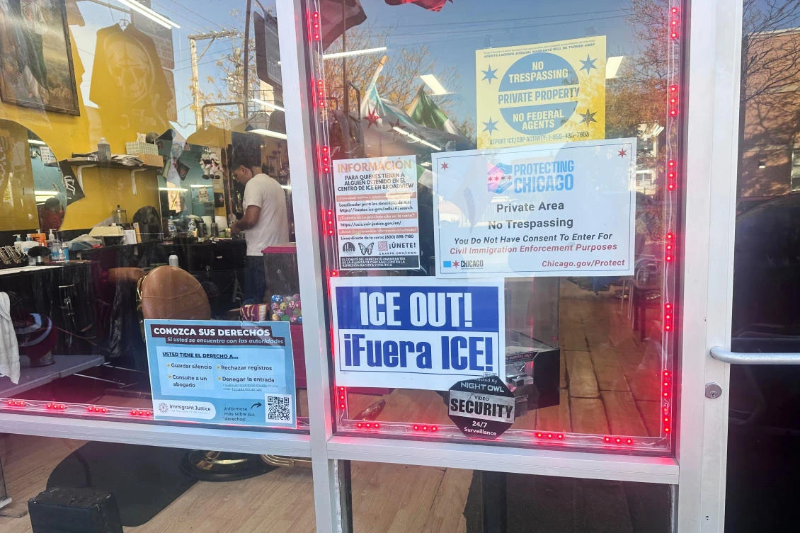Above, a sign reads “ICE OUT” and informs people of their rights outside a barbershop in Chicago on Oct., 28, 2025. (AP)