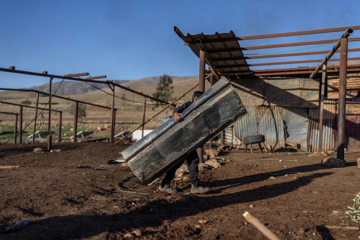 A Bedouin family dismantles a structure as they gather their belongings to leave their home after continues harassment from Israeli right-wing settlers in Ras Ein al-Auja, near the city of Jericho in the Israel-occupied Palestinian West Bank, Jan. 11, 2026. (AFP)