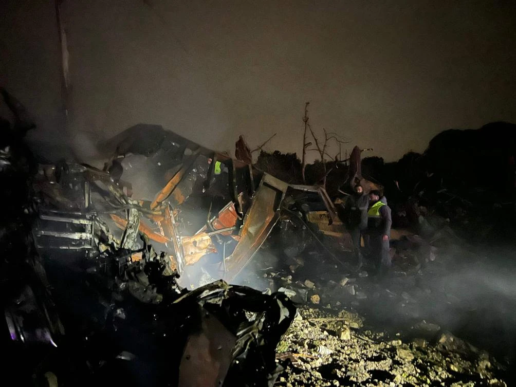 Firefighters look on after extinguishing a blaze caused by an Israeli airstrike that targeted a complex of large industrial machinery in the southern Lebanese village of Al-Marwanieh, on Jan. 30, 2026. (AFP)