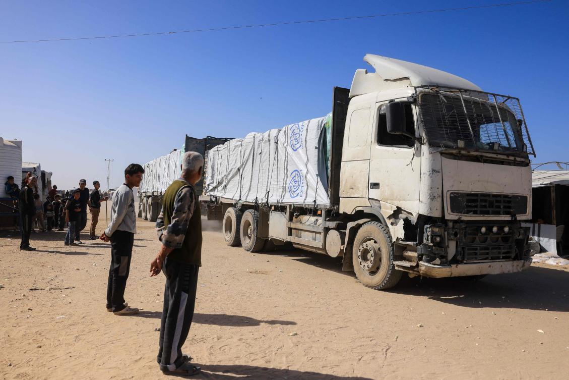 Palestinians look on as trucks carrying humanitarian aid arrive in Khan Yunis in the southern Gaza Strip, after passing through the Rafah border crossing from Egypt, on February 1, 2026. (AFP)