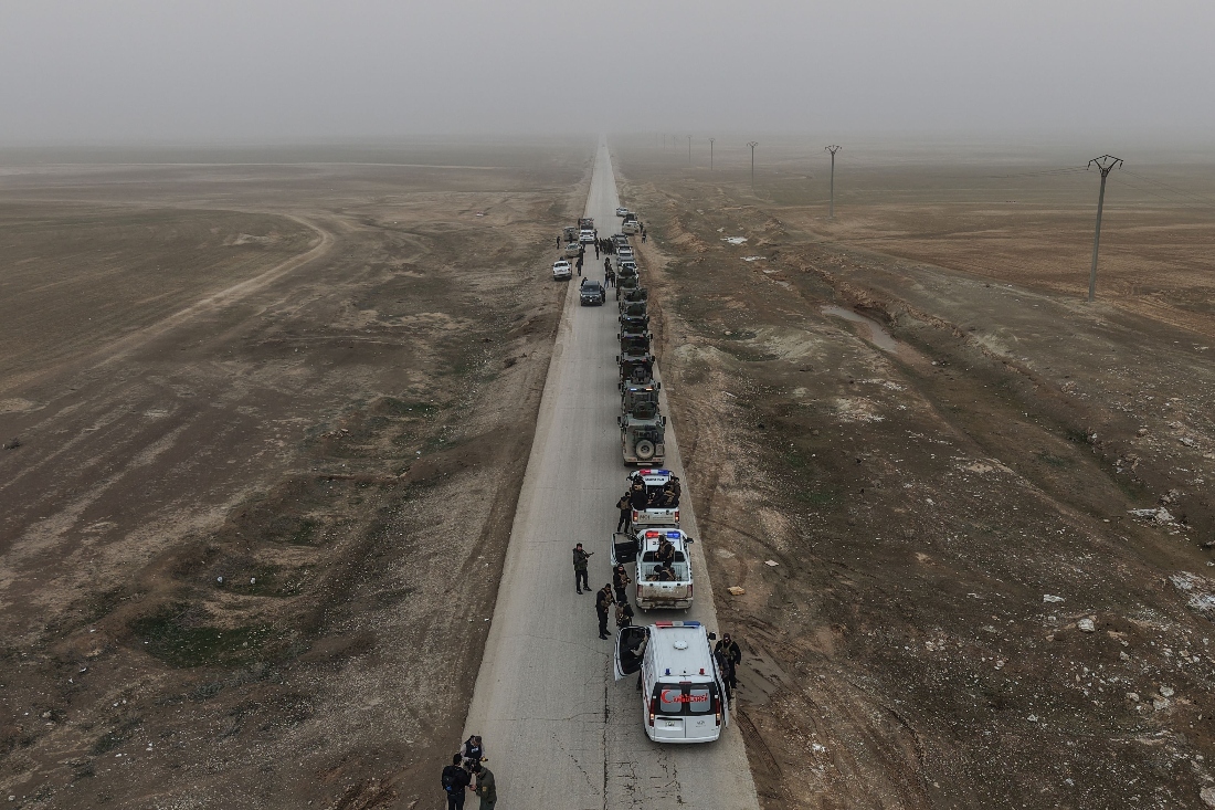 An aerial view shows a Syrian government forces military convoy driving along a road in the countryside near the northeastern Syrian city of Hasakeh. (AFP)