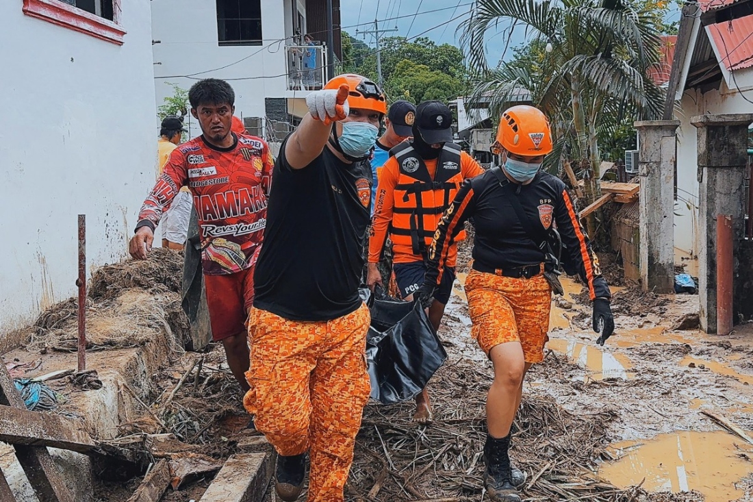 A photo dated 2025 and released by the Bureau of Fire Protection Biliran provincial Office (BFP-BILIRAN) shows Bureau of Fire Protection personnel carrying a body bag containing a landslide victim in the aftermath of Severe Tropical Storm Bualoi at a village in Kawayan town, Philippines. (AFP)