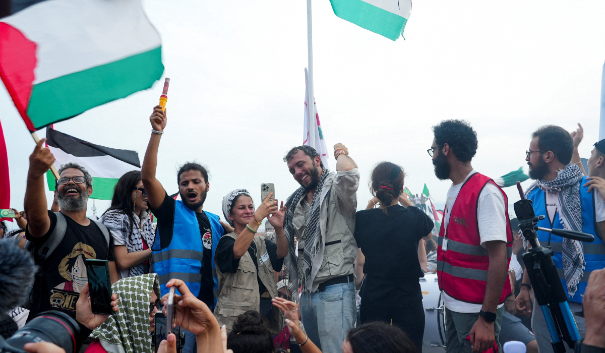 Brazilian activist Thiago Avila and activist Yasemin Acar, members of the Global Sumud Flotilla, surrounded by supporters of the Palestinian cause, gesture during a press conference on the beach of Sidi Bou Said, near Tunis, Tunisia, September 7, 2025. (REUTERS)
