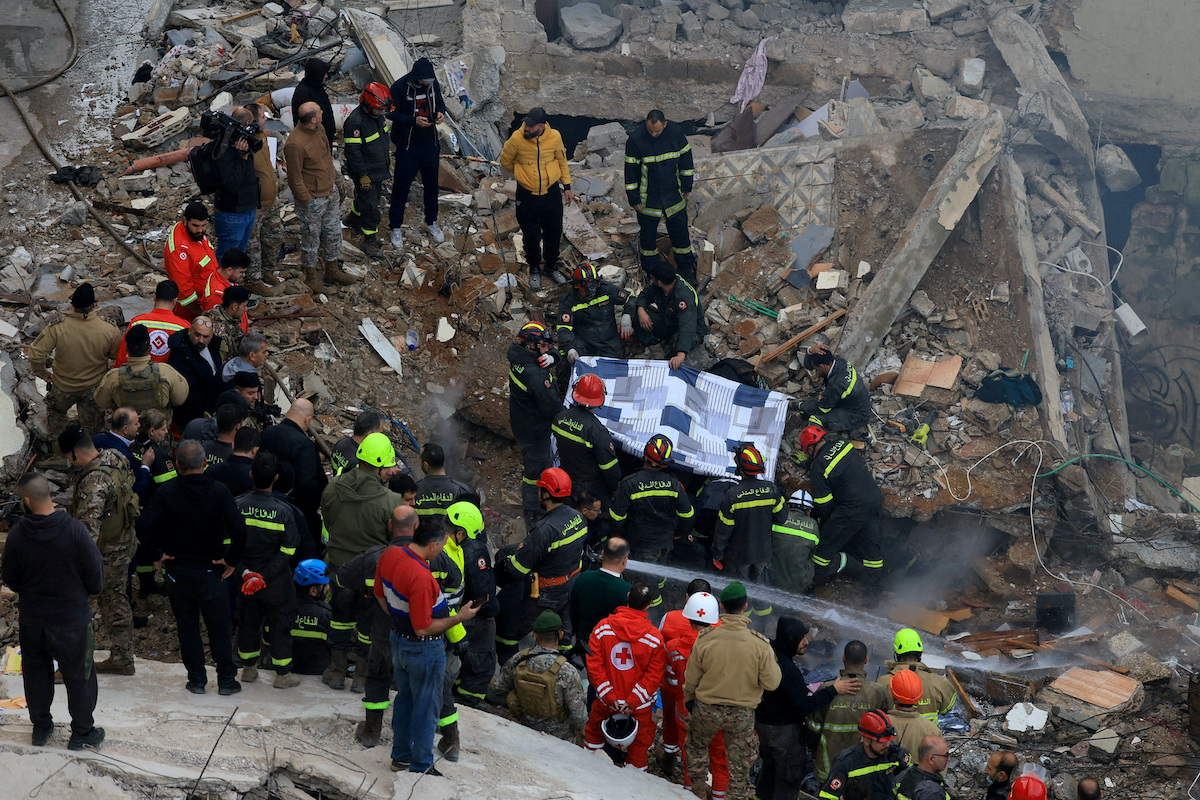 Rescue workers remove a body from under the rubble after a residential building collapsed in Tripoli, Lebanon. (Reuters)