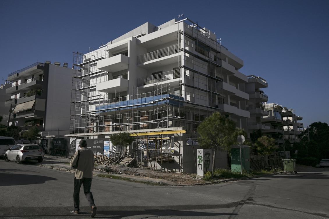 A man walks pass an apartment building under construction at a southern suburb of Athens, on March 30, 2024. (FILE/AFP)