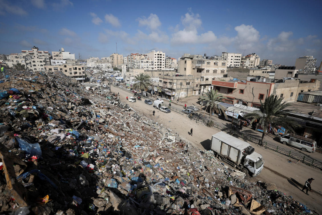 Palestinians walk near a landfill, in Gaza City, February 11, 2026. (REUTERS)