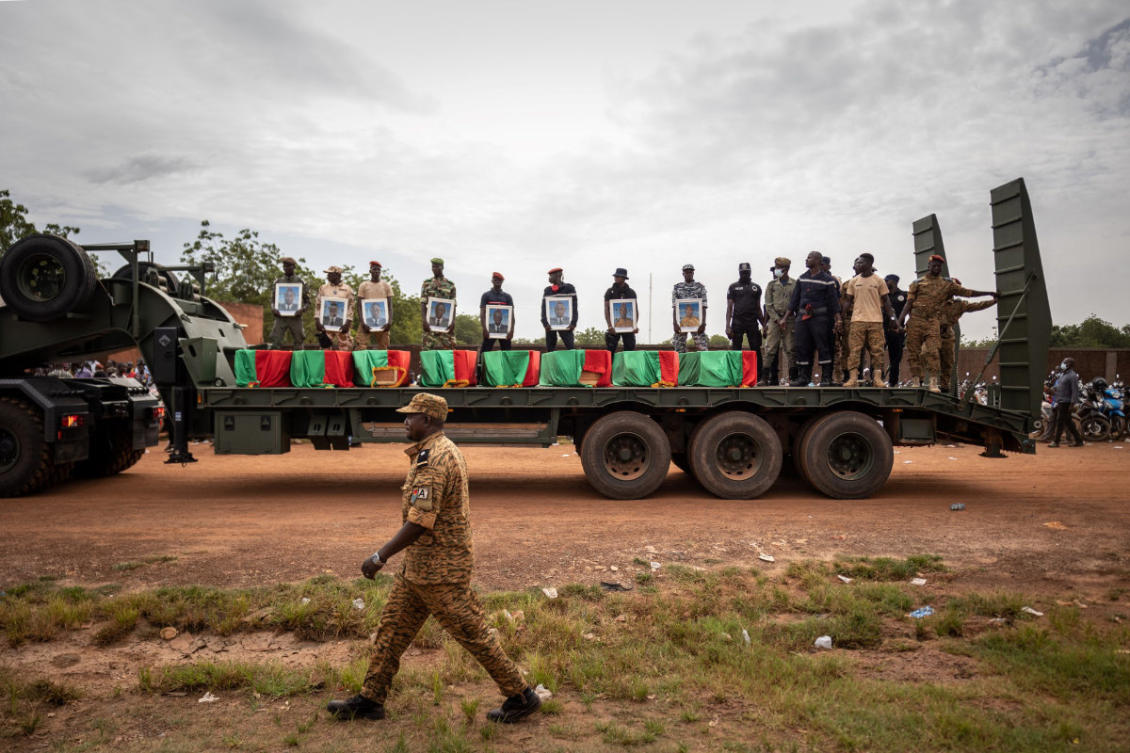In this photo taken on October 8, 2022, a trailer truck carries the flag draped coffins of slain Burkina Faso soldiers during their funeral at the General Sangoule Lamizana military camp in Ouagadougou. The soldiers were killed in battle with jihadis. (AFP/file photo)