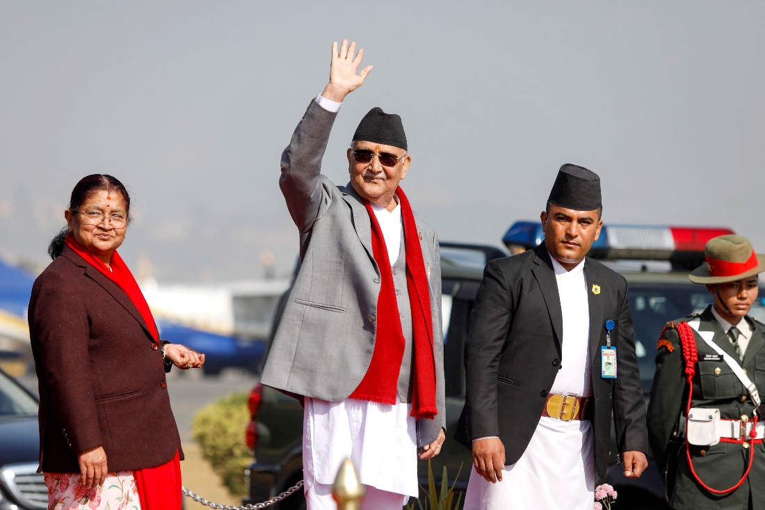 Nepal's Prime Minister Khadga Prasad Sharma Oli waves alongside his wife Radhika Shakya before his departure, at the Tribhuvan International airport in Kathmandu, Nepal. (AFP)