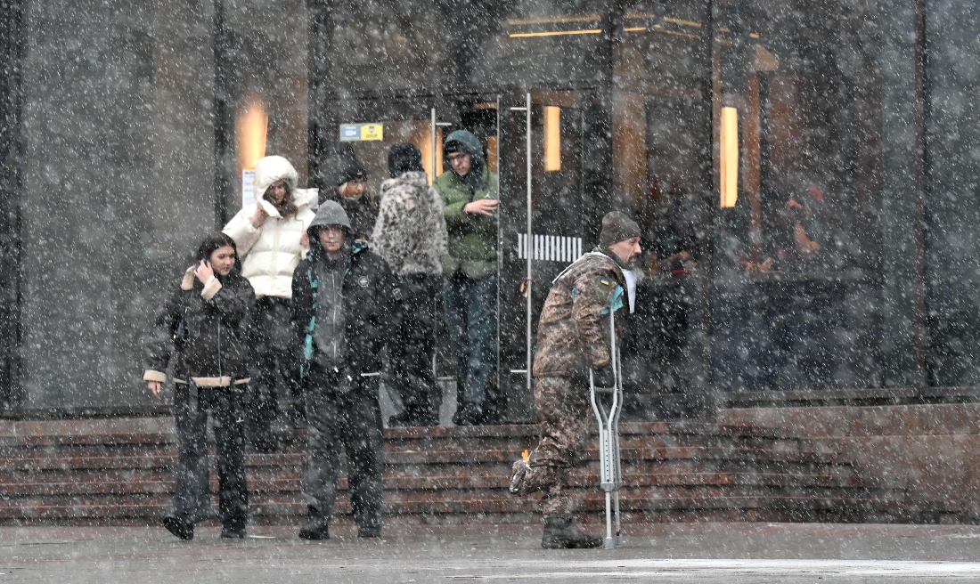 A wounded Ukrainian serviceman walks in a street in Kyiv during snow fall in Ukraine. (AFP)