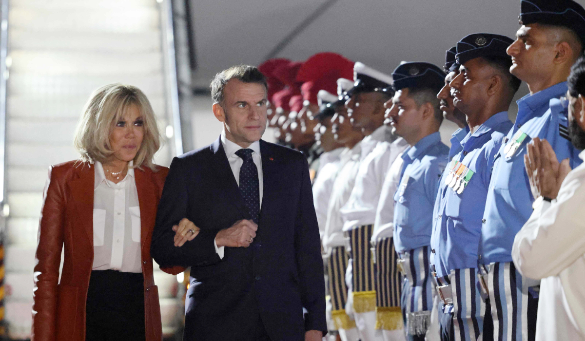 France's President Emmanuel Macron (C-R) and his wife Brigitte Macron (L) are welcomed by India's officials upon their arrival in Mumbai on February 17, 2026. (AFP)