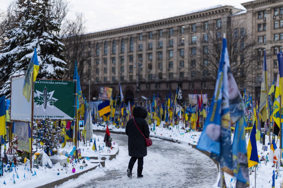 A woman walks amongst a makeshift memorial to fallen Ukrainian and foreign soldiers at Independence Square, central Kyiv, Feb. 17, 2026. (AFP)